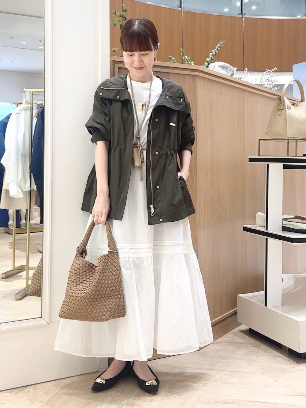 ブラウン系のショルダーバッグ、グレー系のブルゾン、ホワイト系のTシャツ/カットソーを着用したレディースの春コーディネートの5枚目の写真