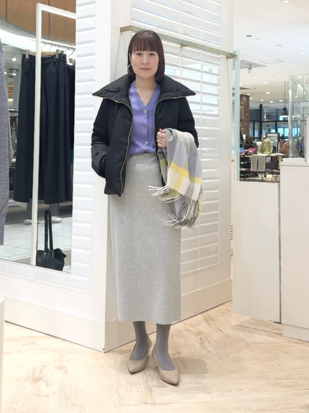 ブラック系のダウンジャケット/コート、パープル系のカーディガン/ボレロ、グレー系のスカートを着用したレディースの秋コーディネートの4枚目の写真