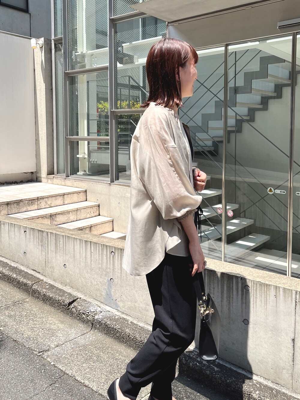 ブラック系のショルダーバッグ、ベージュ系のシャツ/ブラウス、ブラック系のその他パンツを着用したレディースの夏コーディネートの5枚目の写真