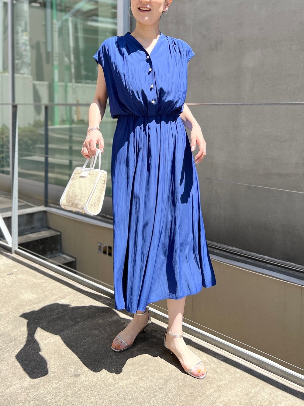 ホワイト系のトートバッグ、ブルー系のワンピース、ホワイト系のサンダルを着用したレディースの春コーディネートの4枚目の写真