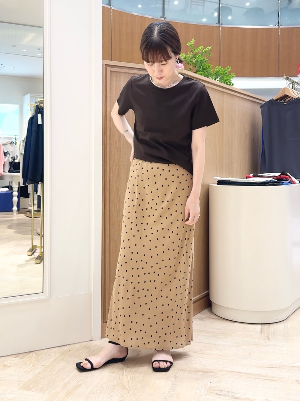 ブラウン系のスカート、ブラウン系のTシャツ/カットソー、シルバー系のチョーカーを着用したレディースの夏コーディネートの7枚目の写真