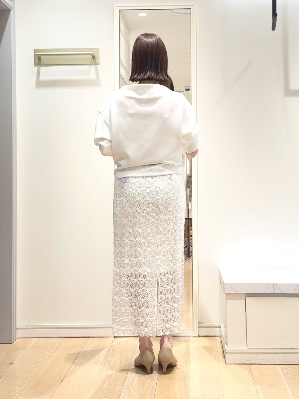 ホワイト系のTシャツ/カットソー、ホワイト系のスカート、ゴールド系のネックレスを着用したレディースの春コーディネートの4枚目の写真