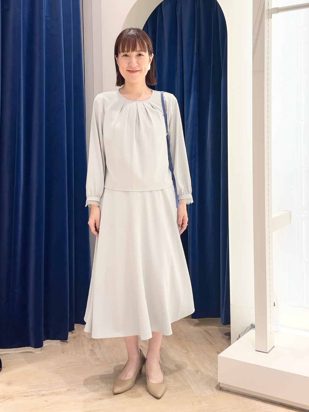 ブルー系のスカート、ブルー系のシャツ/ブラウス、ホワイト系のショルダーバッグを着用したレディースの秋コーディネートの6枚目の写真