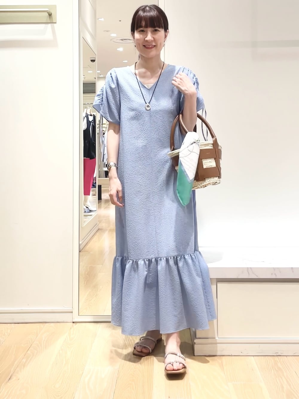 ブルー系のワンピース、グリーン系のバンダナ/スカーフ、ゴールド系のイヤリングを着用したレディースの春コーディネートの5枚目の写真