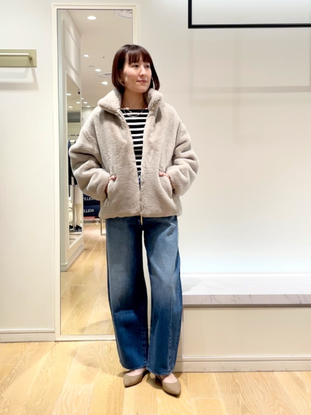 ブルー系のデニムパンツ、グレー系のブルゾン、ブラック系のニット/セーターを着用したレディースの秋コーディネートの2枚目の写真