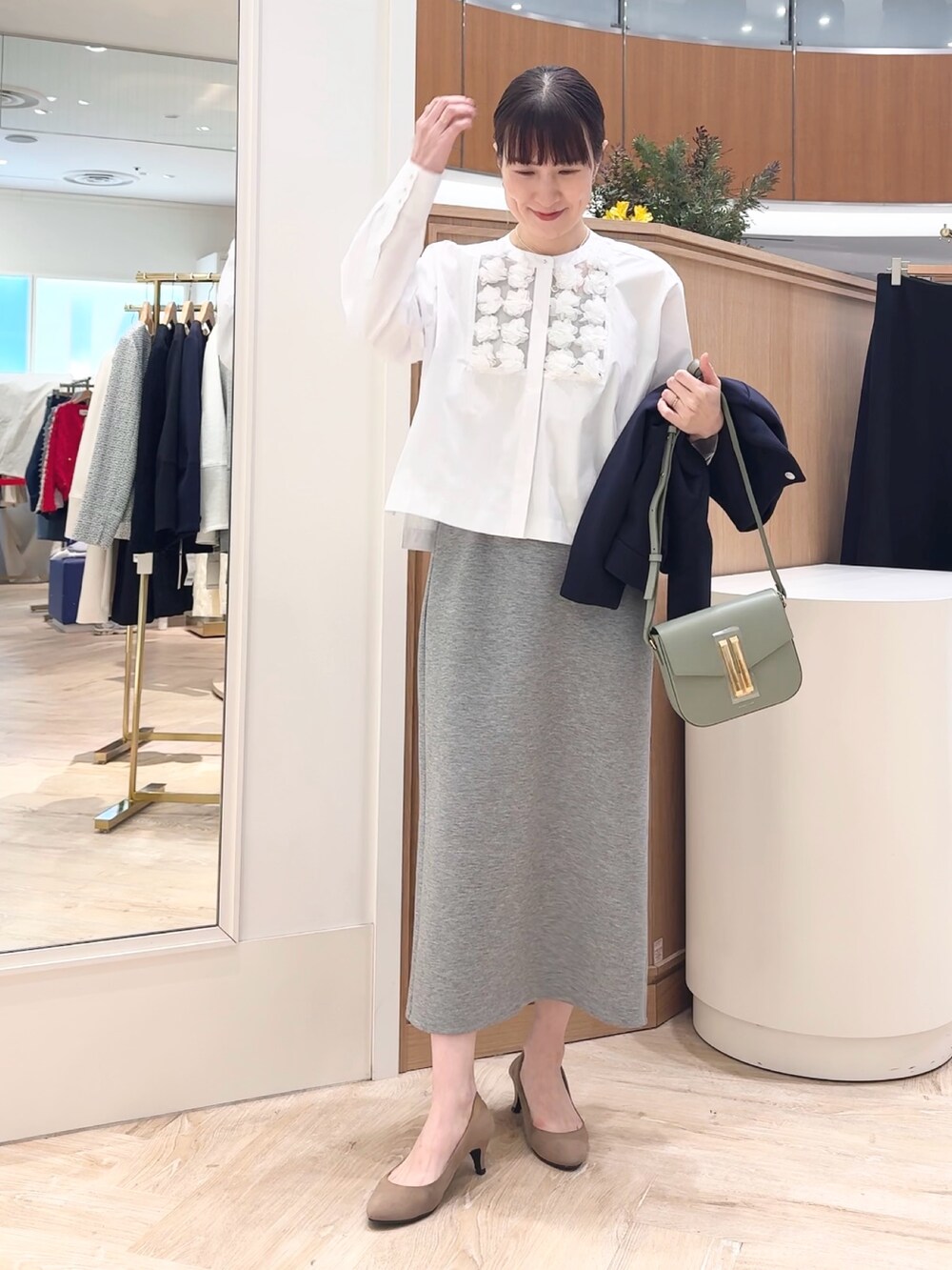 グレー系のスカート、ブルー系のブルゾン、ホワイト系のシャツ/ブラウスを着用したレディースの冬コーディネートの5枚目の写真