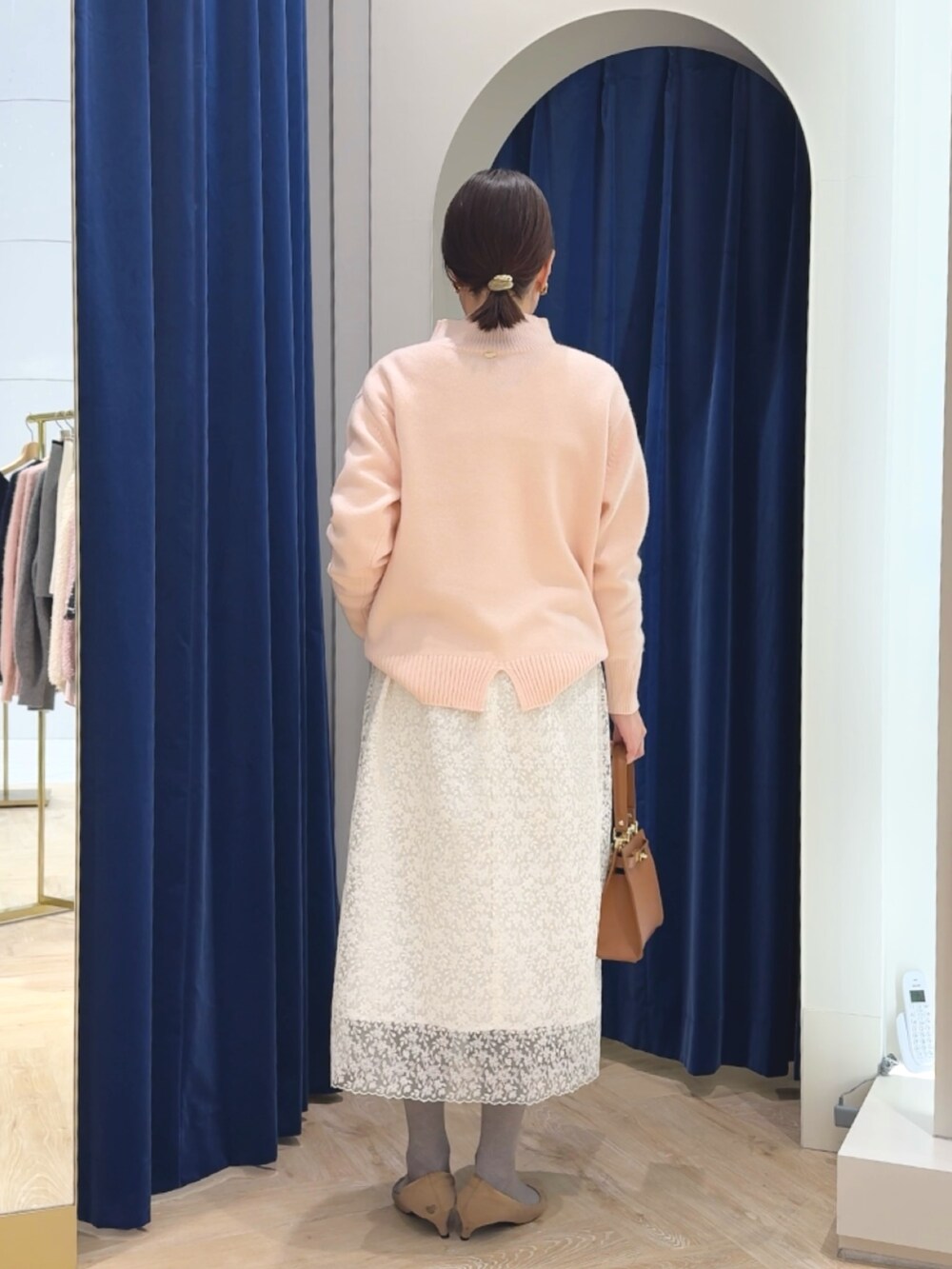 ピンク系のニット/セーター、イエロー系のショルダーバッグ、ホワイト系のスカートを着用したレディースの冬コーディネートの7枚目の写真