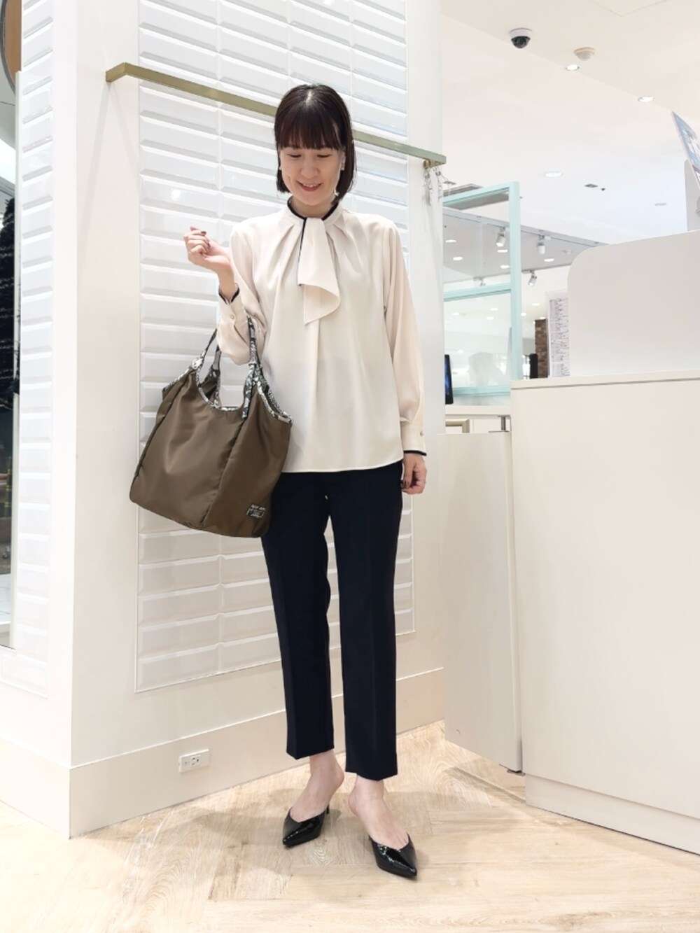 ブルー系のその他パンツ、ブラウン系のトートバッグ、ホワイト系のシャツ/ブラウスを着用したレディースの秋コーディネートの3枚目の写真