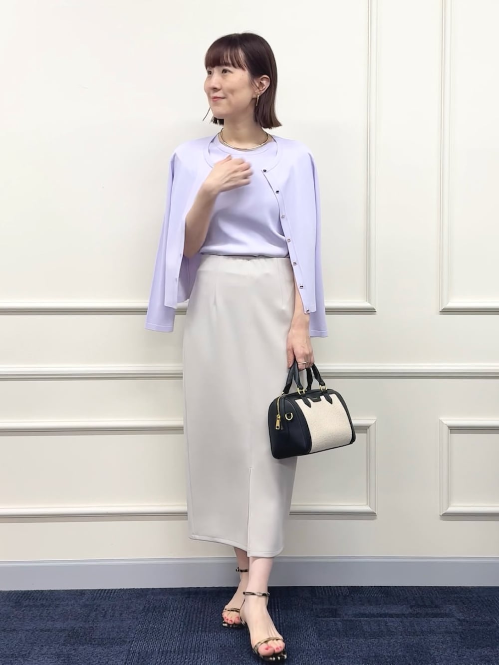 ブラック系のボストンバッグ、パープル系のカーディガン/ボレロ、パープル系のニット/セーターを着用したレディースの春コーディネートの6枚目の写真