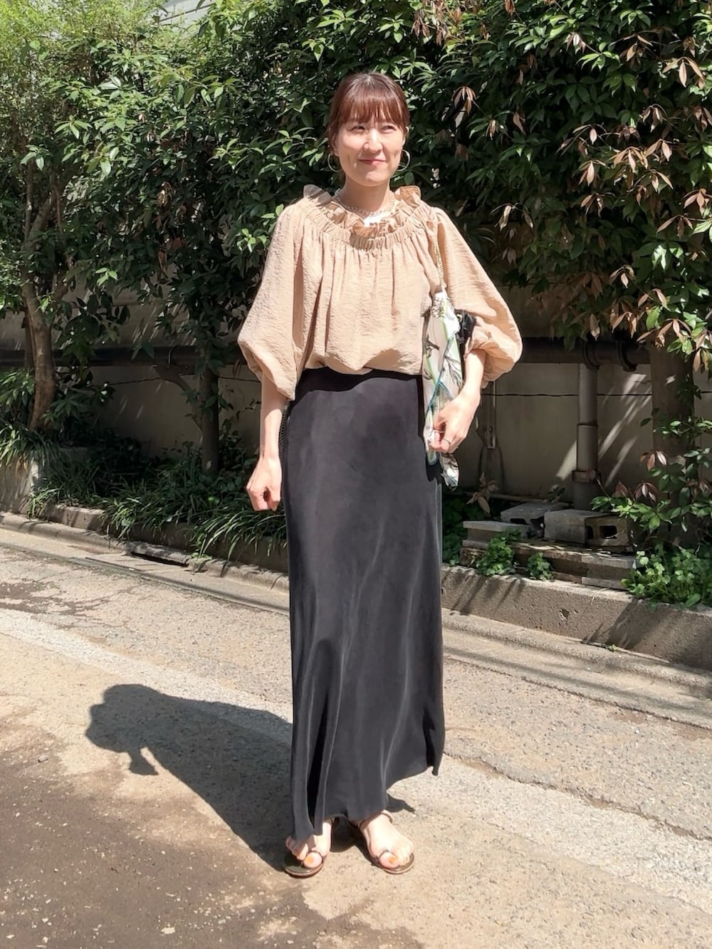 ブラック系のスカート、イエロー系のシャツ/ブラウス、その他のネックレスを着用したレディースの春コーディネートの4枚目の写真