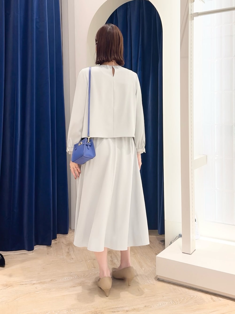 ブルー系のスカート、ブルー系のシャツ/ブラウス、ホワイト系のショルダーバッグを着用したレディースの秋コーディネートの5枚目の写真