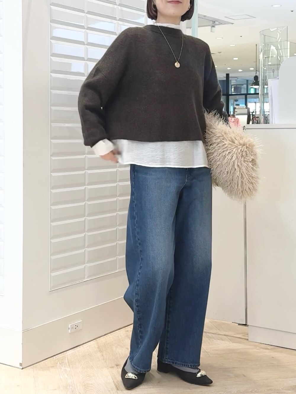 ベージュ系のショルダーバッグ、ホワイト系のシャツ/ブラウス、ブラウン系のニット/セーターを着用したレディースの冬コーディネートの9枚目の写真