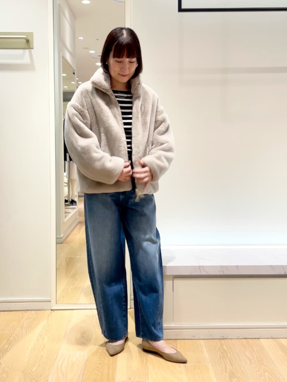 ブルー系のデニムパンツ、グレー系のブルゾン、ブラック系のニット/セーターを着用したレディースの秋コーディネートの4枚目の写真