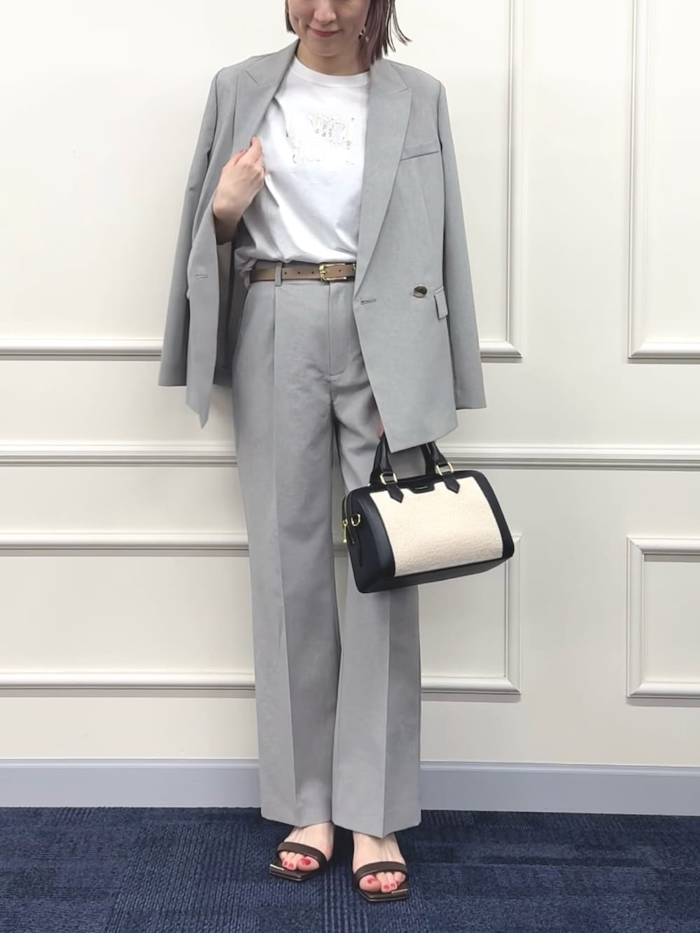 ブラック系のボストンバッグ、グレー系のその他パンツ、ホワイト系のTシャツ/カットソーを着用したレディースの春コーディネートの6枚目の写真