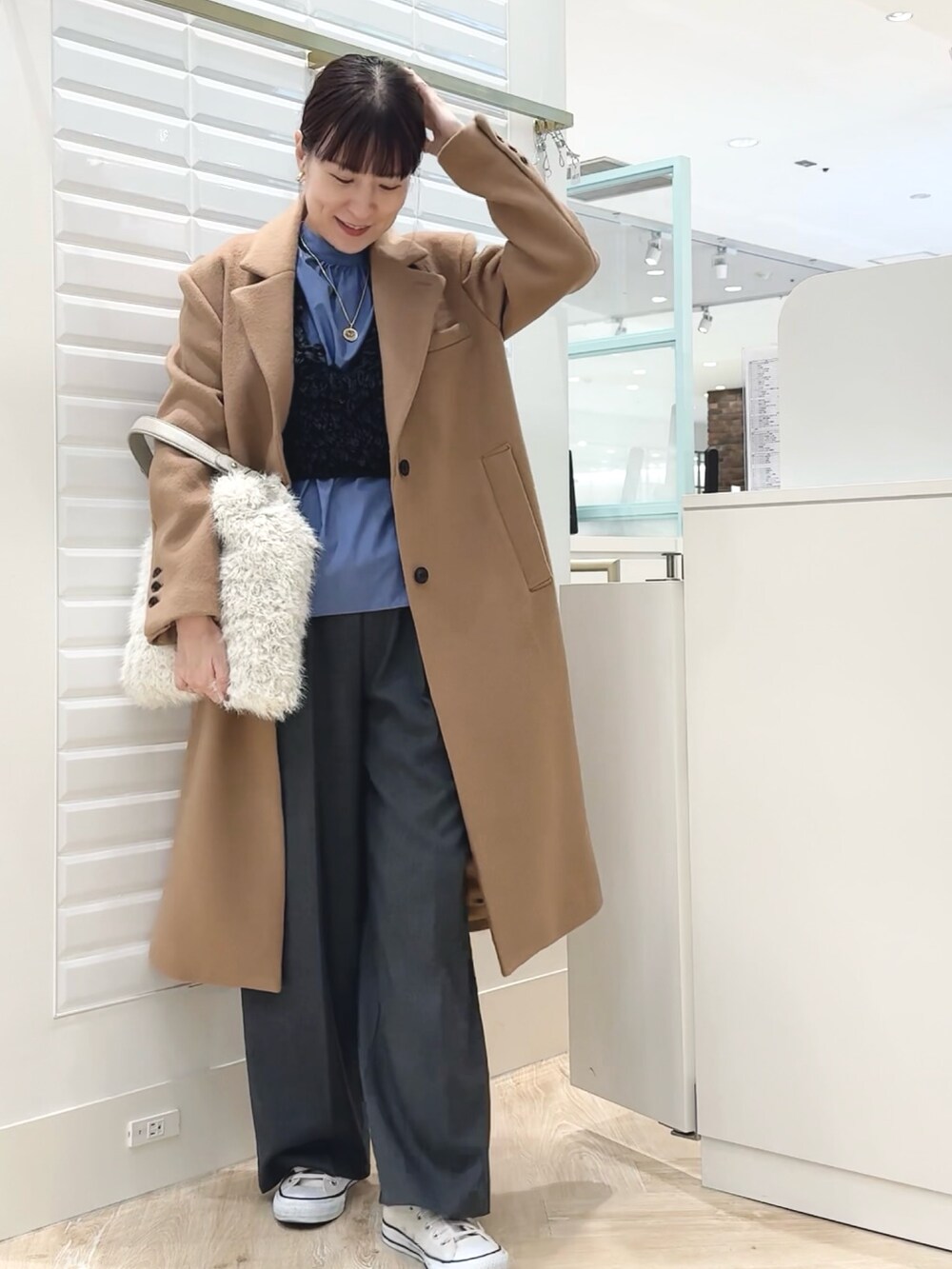 グレー系のベスト、ブルー系のシャツ/ブラウス、ホワイト系のショルダーバッグを着用したレディースの秋コーディネートの8枚目の写真