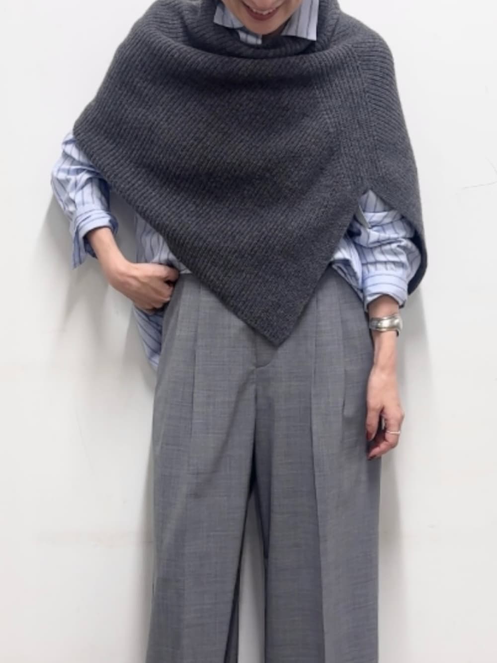グレー系のニット/セーター、グレー系のその他パンツ、ブルー系のシャツ/ブラウスを着用したレディースの秋コーディネートの7枚目の写真