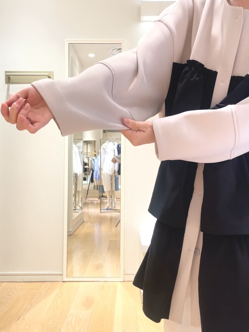 ベージュ系のその他アウター、ブラック系のショルダーバッグを着用したレディースの春コーディネートの5枚目の写真