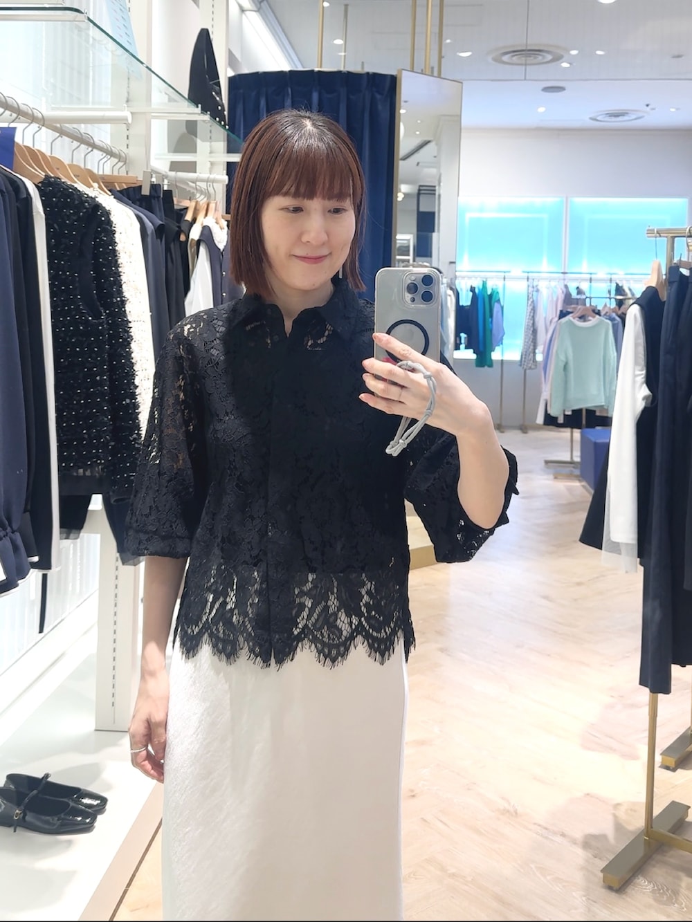 ホワイト系のスカート、ブラック系のシャツ/ブラウス、ブラック系のタンクトップを着用したレディースの春コーディネートの6枚目の写真