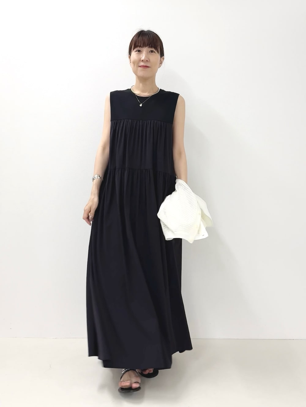 ブラック系のサンダル、ホワイト系のカーディガン/ボレロ、ブルー系のワンピースを着用したレディースの夏コーディネートの9枚目の写真