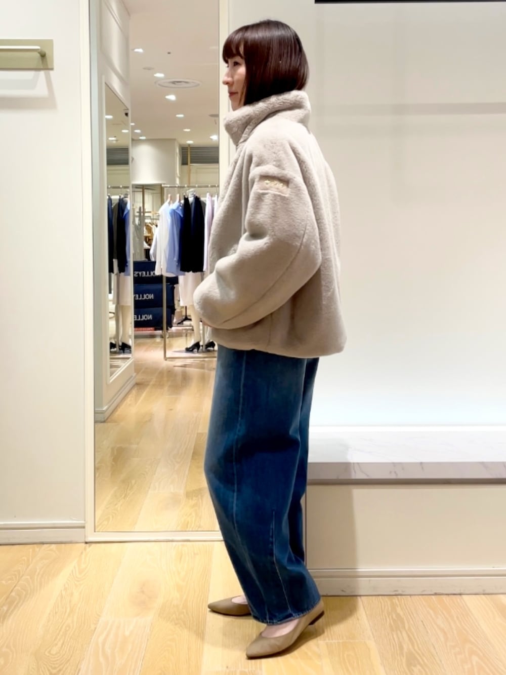 ブルー系のデニムパンツ、グレー系のブルゾン、ブラック系のニット/セーターを着用したレディースの秋コーディネートの3枚目の写真