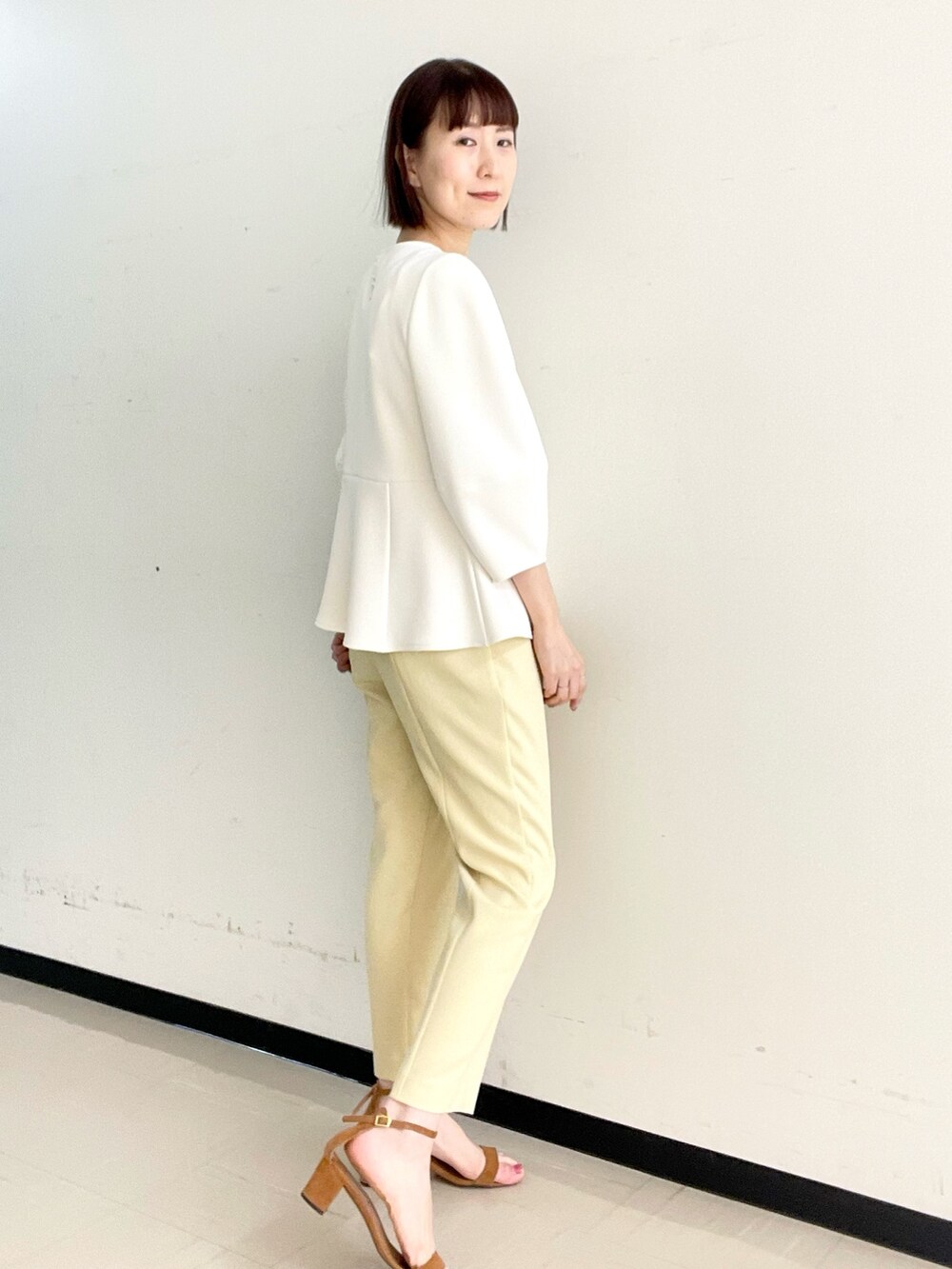 イエロー系のその他パンツ、ホワイト系のTシャツ/カットソー、ゴールド系のイヤーカフを着用したレディースの冬コーディネートの2枚目の写真