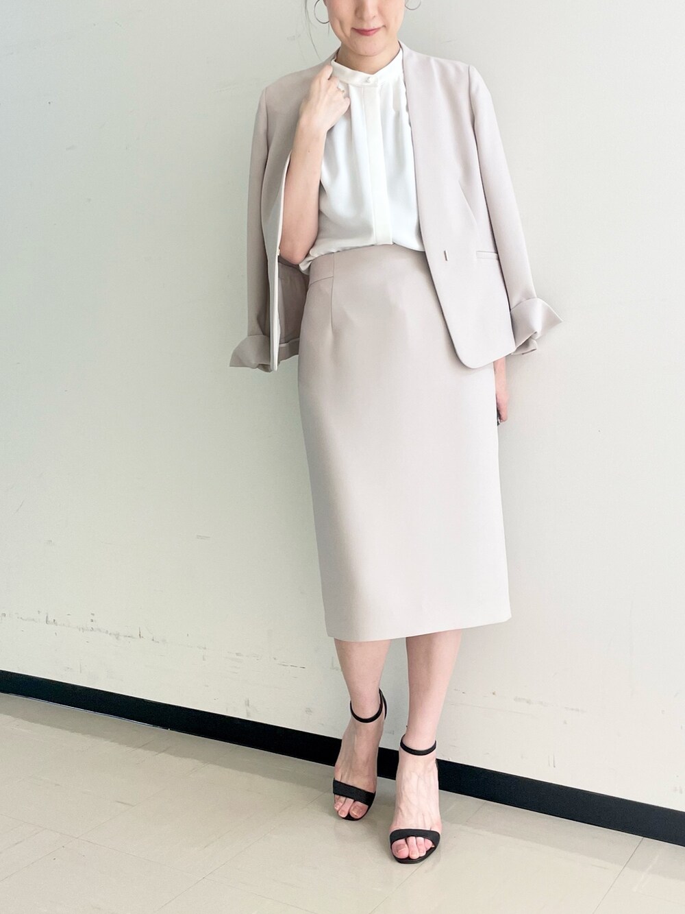 ベージュ系のスカート、ホワイト系のシャツ/ブラウス、ベージュ系のノーカラージャケットを着用したレディースの春コーディネートの4枚目の写真