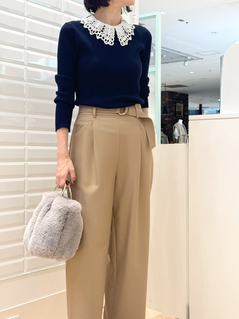 ベージュ系のその他パンツ、グレー系のショルダーバッグ、ブルー系のニット/セーターを着用したレディースの秋コーディネートの2枚目の写真