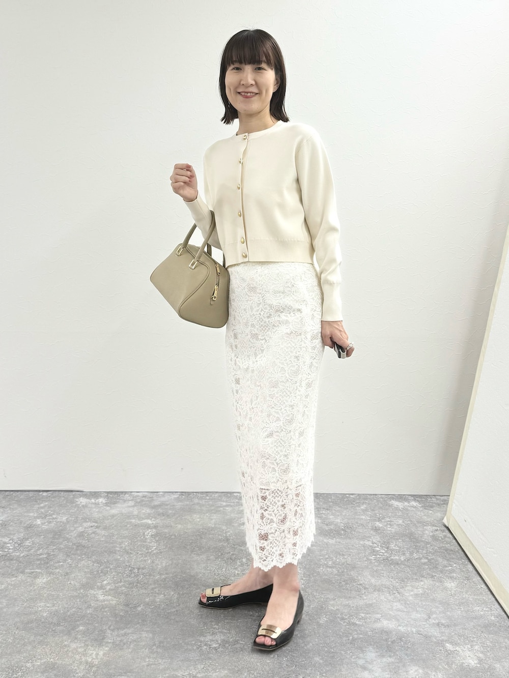 ホワイト系のカーディガン/ボレロ、ベージュ系のショルダーバッグ、ホワイト系のスカートを着用したレディースの秋コーディネートの9枚目の写真
