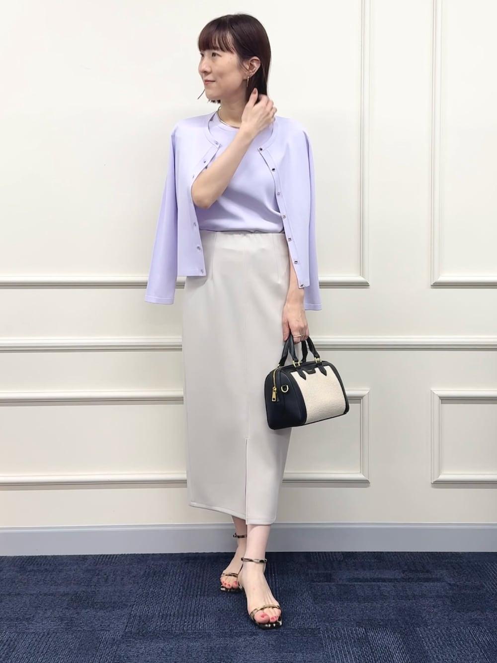 ブラック系のボストンバッグ、パープル系のカーディガン/ボレロ、パープル系のニット/セーターを着用したレディースの春コーディネートの9枚目の写真