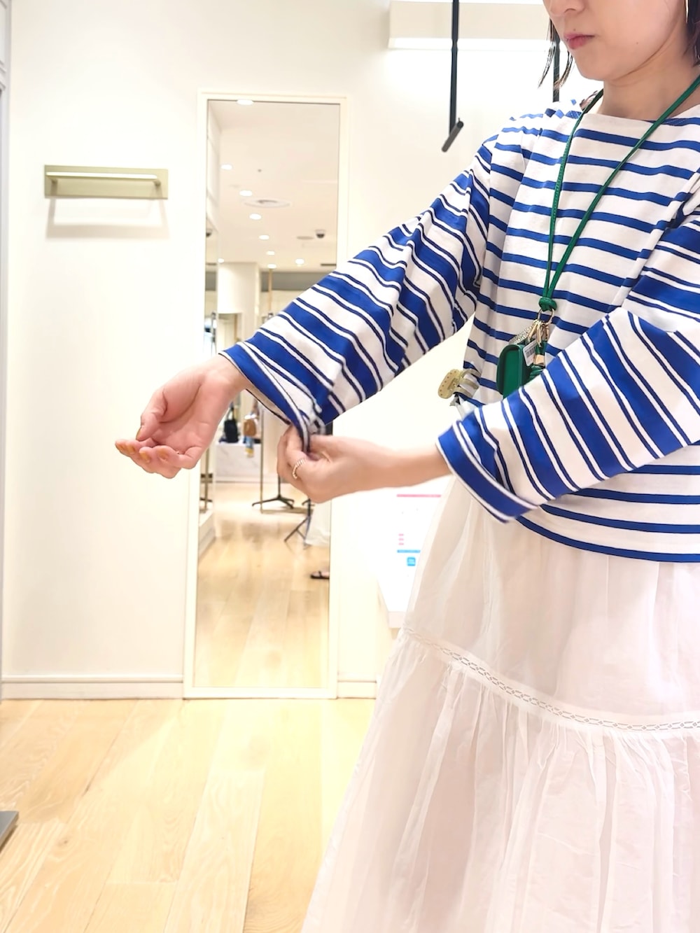 ブルー系のTシャツ/カットソー、グリーン系のチャーム、ベージュ系のヘアゴムを着用したレディースの春コーディネートの5枚目の写真