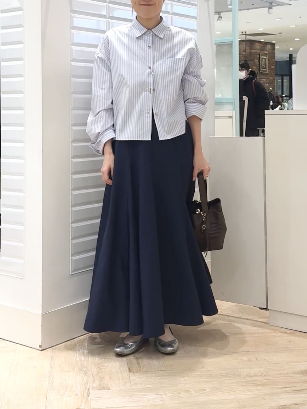 ブルー系のシャツ/ブラウス、ブルー系のスカート、ブラウン系のショルダーバッグを着用したレディースの春コーディネートの2枚目の写真