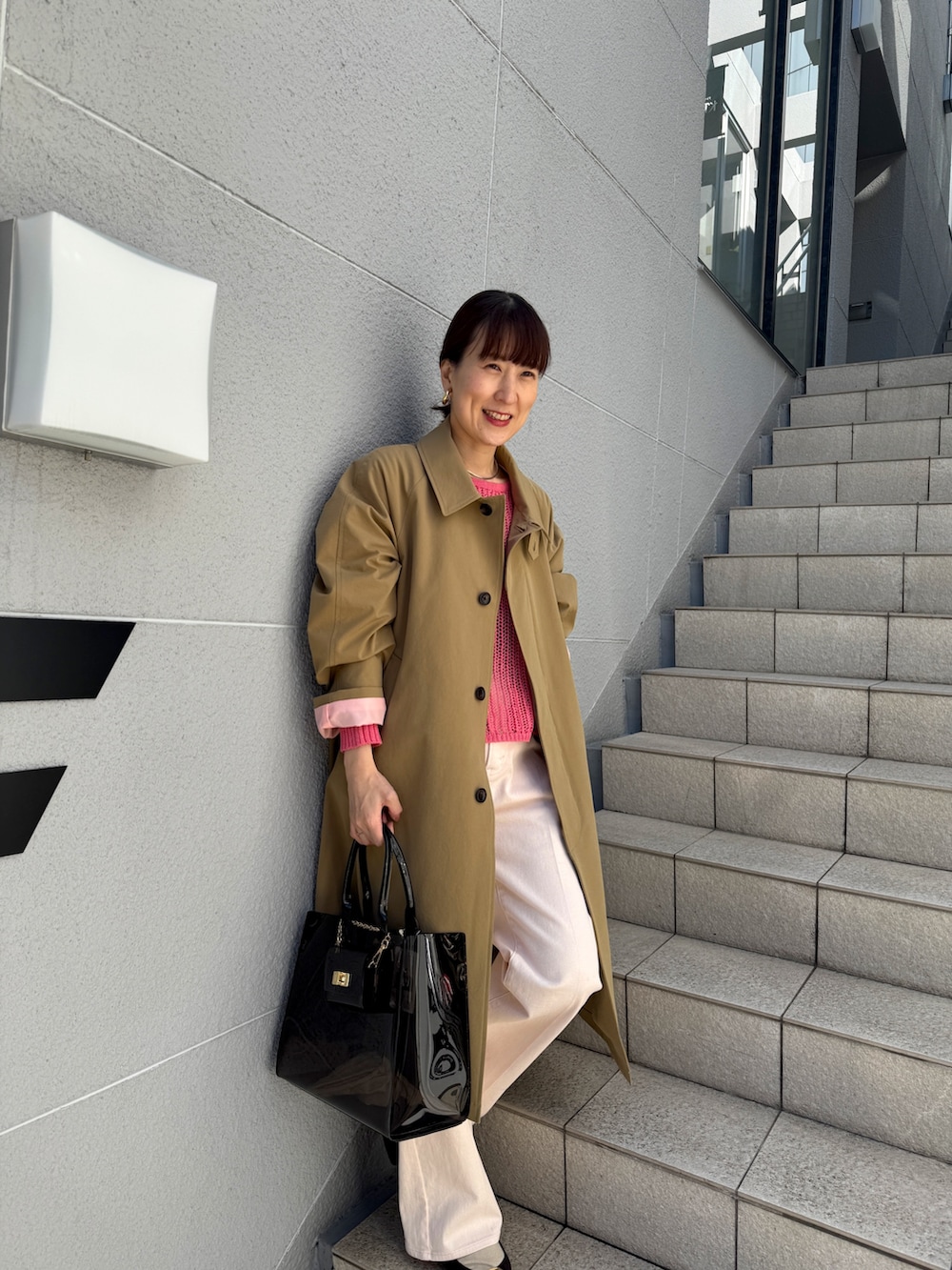 ピンク系のニット/セーター、ベージュ系のダッフルコート、ピンク系のデニムパンツを着用したレディースの冬コーディネートの9枚目の写真