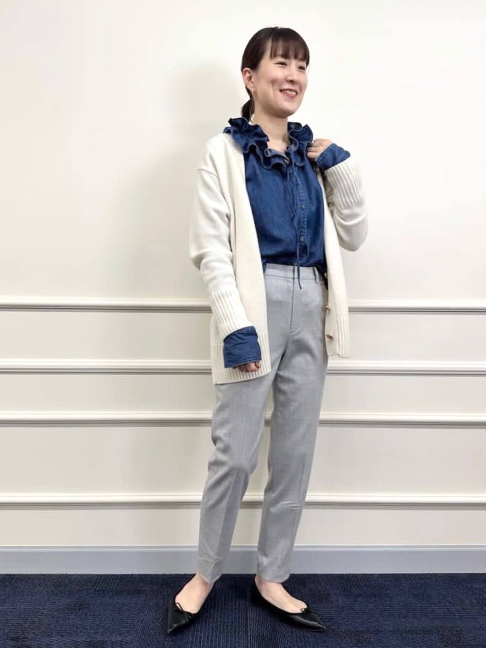 ブラック系のパンプス、グレー系のその他パンツ、ホワイト系のカーディガン/ボレロを着用したレディースの冬コーディネートの9枚目の写真