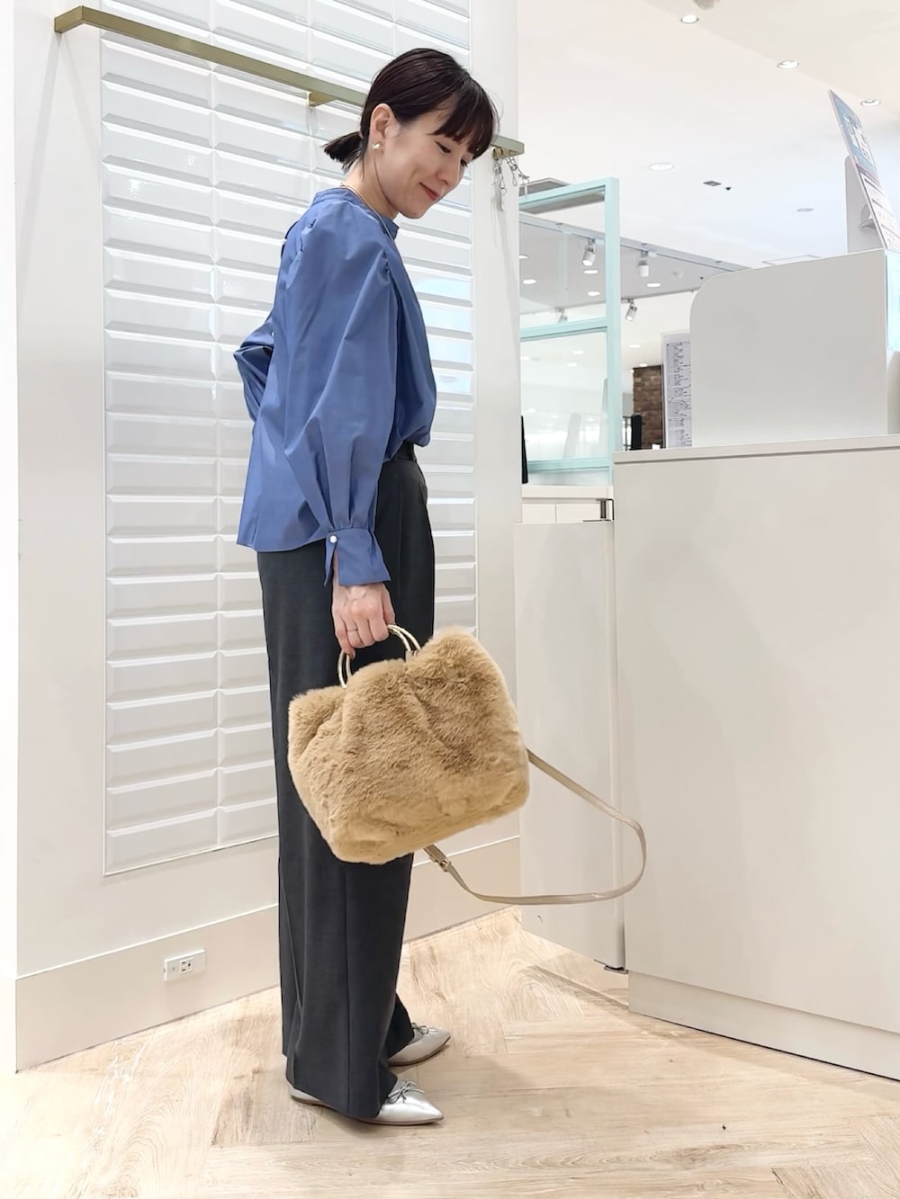 ブルー系のシャツ/ブラウス、ベージュ系のショルダーバッグ、グレー系のその他パンツを着用したレディースの秋コーディネートの3枚目の写真