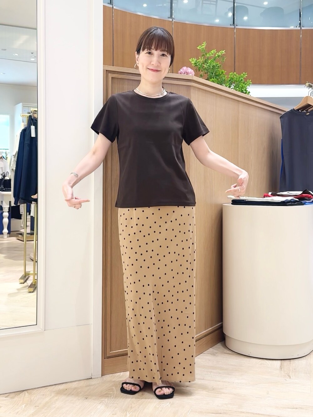 ブラウン系のスカート、ブラウン系のTシャツ/カットソー、シルバー系のチョーカーを着用したレディースの夏コーディネートの2枚目の写真