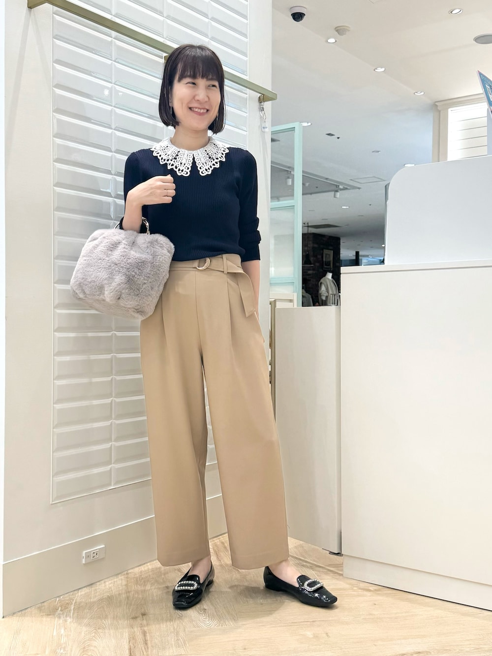 ベージュ系のその他パンツ、グレー系のショルダーバッグ、ブルー系のニット/セーターを着用したレディースの秋コーディネートの4枚目の写真