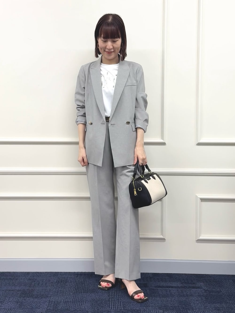 ブラック系のボストンバッグ、グレー系のその他パンツ、ホワイト系のTシャツ/カットソーを着用したレディースの春コーディネートの9枚目の写真