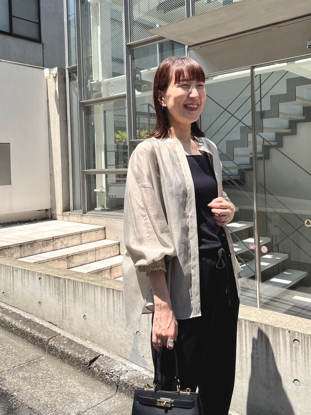 ブラック系のショルダーバッグ、ベージュ系のシャツ/ブラウス、ブラック系のその他パンツを着用したレディースの夏コーディネートの10枚目の写真