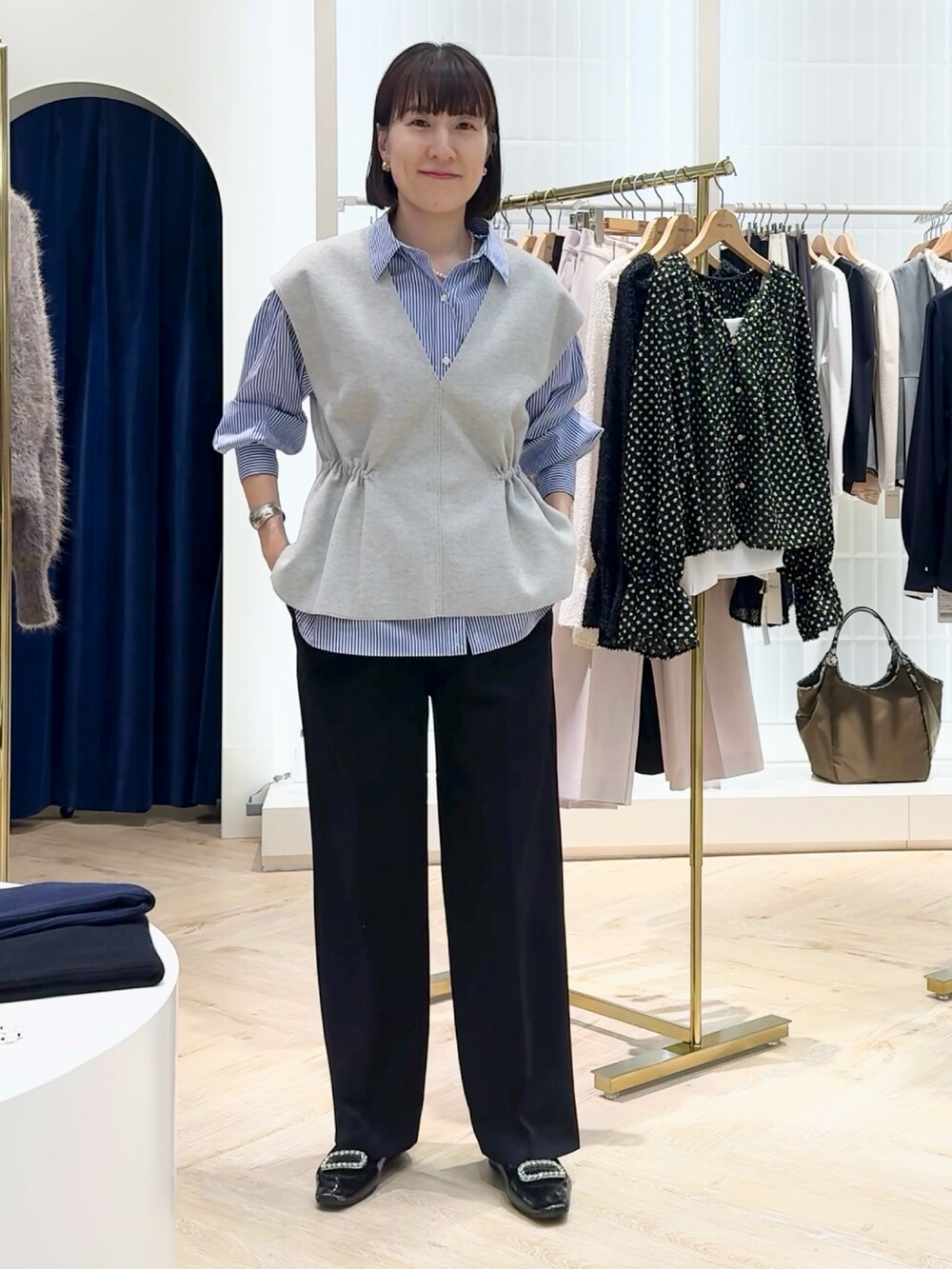 ブルー系のその他パンツ、グレー系のベスト、ブルー系のシャツ/ブラウスを着用したレディースの秋コーディネートの6枚目の写真