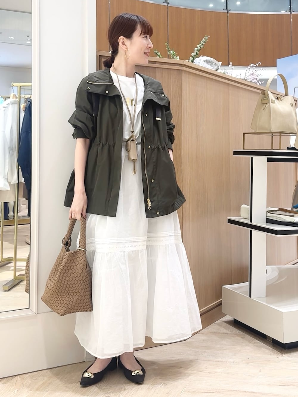 ブラウン系のショルダーバッグ、グレー系のブルゾン、ホワイト系のTシャツ/カットソーを着用したレディースの春コーディネートの3枚目の写真