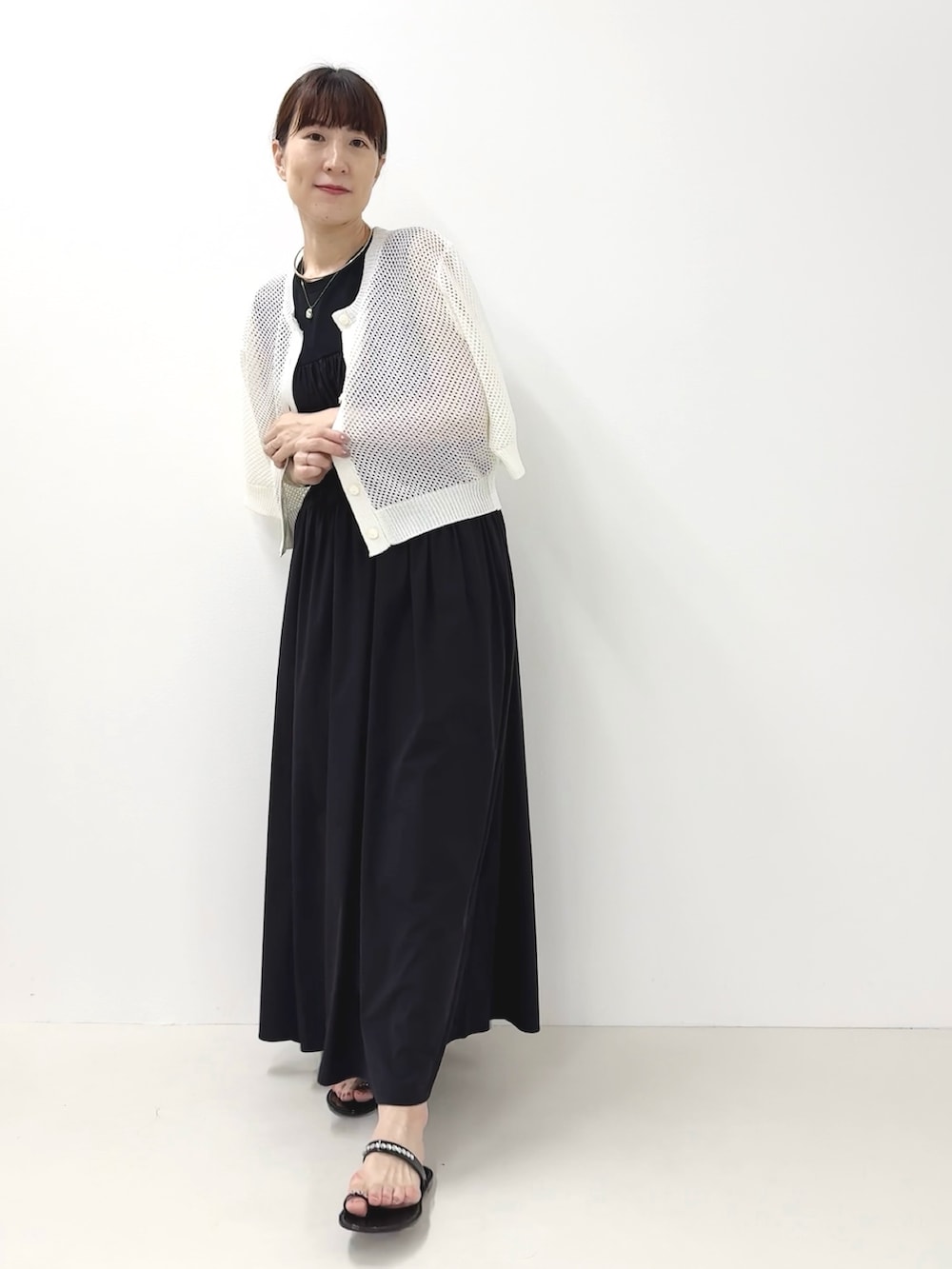 ブラック系のサンダル、ホワイト系のカーディガン/ボレロ、ブルー系のワンピースを着用したレディースの夏コーディネートの2枚目の写真