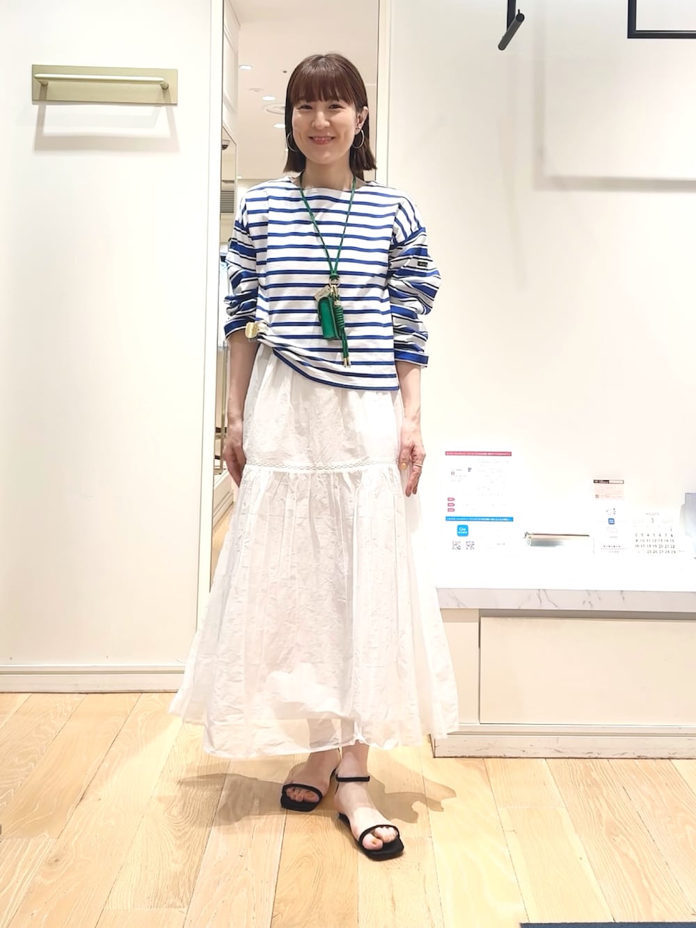 ブルー系のTシャツ/カットソー、グリーン系のチャーム、ベージュ系のヘアゴムを着用したレディースの春コーディネートの4枚目の写真