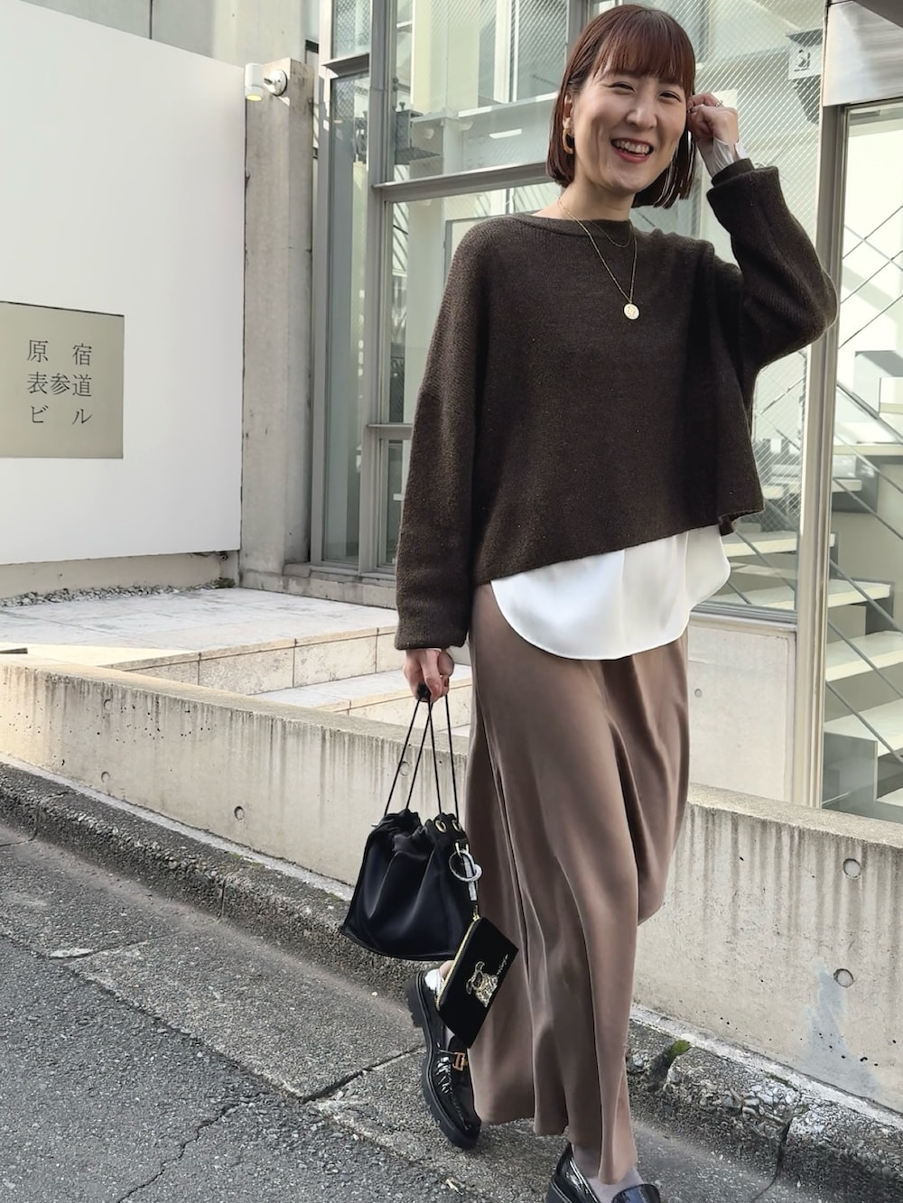 ホワイト系のシャツ/ブラウス、ブラウン系のニット/セーター、ブラック系のその他シューズを着用したレディースの冬コーディネートの4枚目の写真