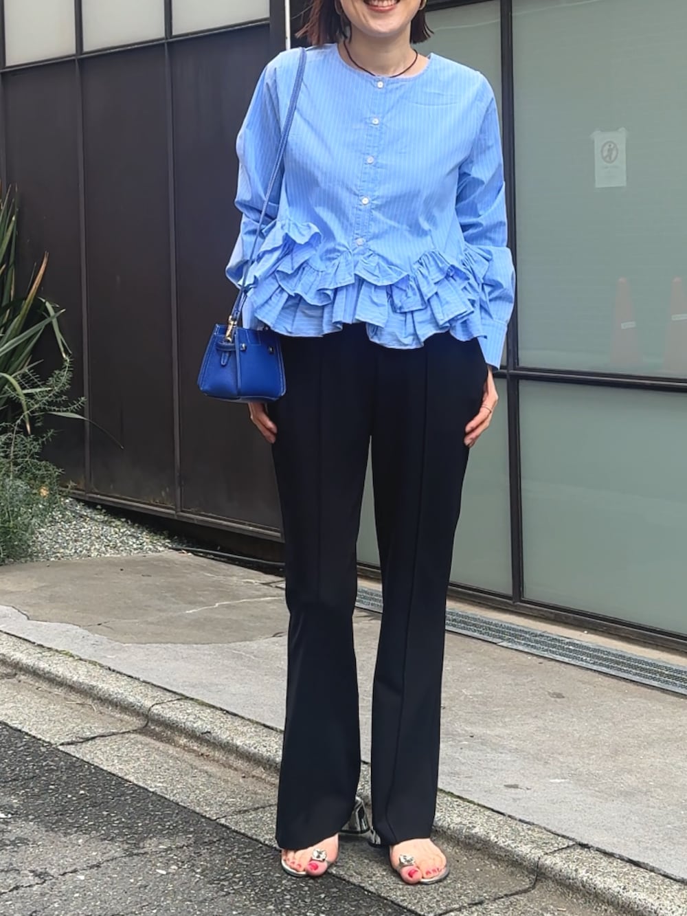 ブルー系のシャツ/ブラウス、ブラック系のその他パンツ、ベージュ系のショルダーバッグを着用したレディースの春コーディネートの2枚目の写真