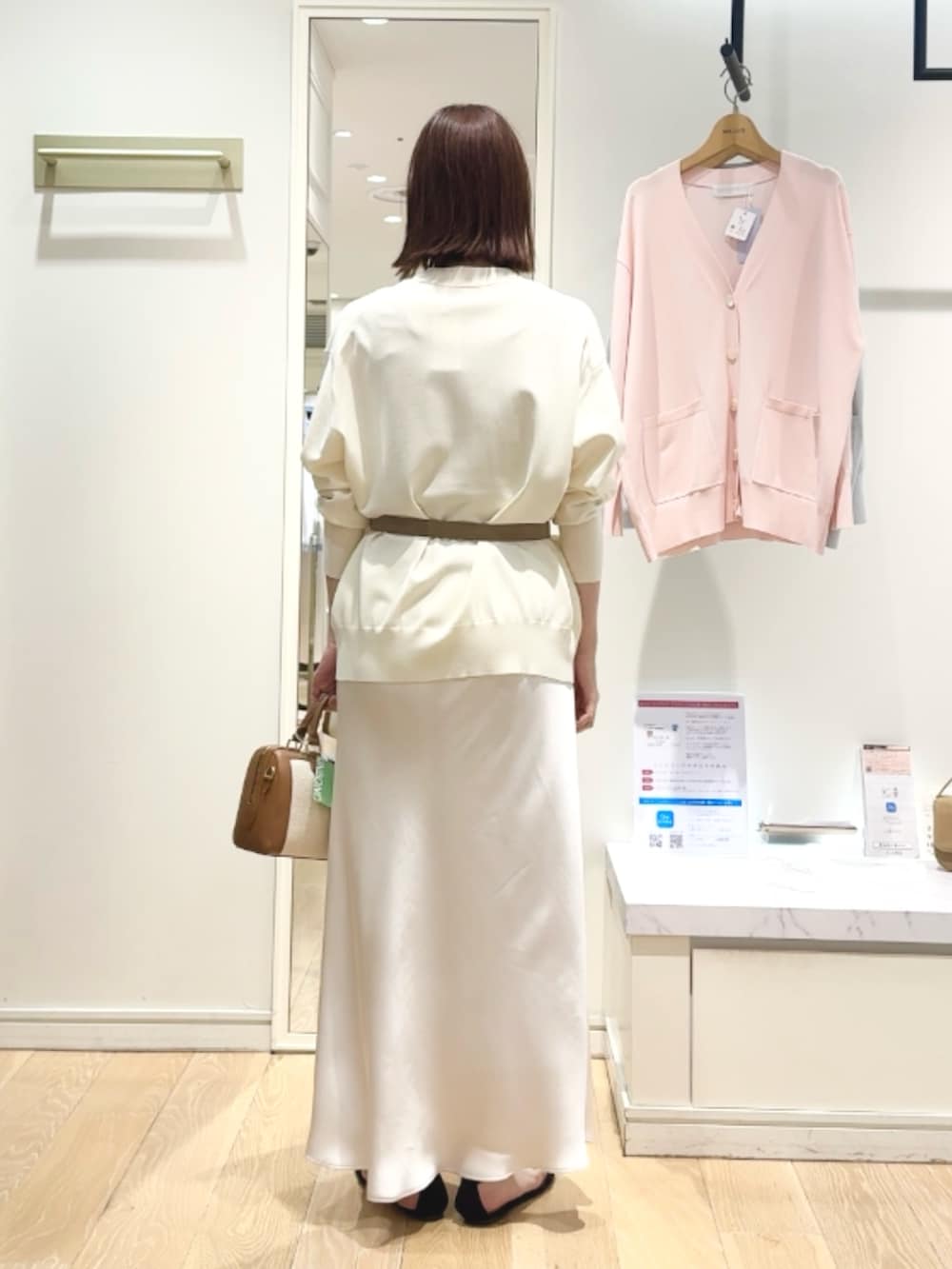 ベージュ系のタンクトップ、ホワイト系のスカート、ブラウン系のボストンバッグを着用したレディースの春コーディネートの4枚目の写真