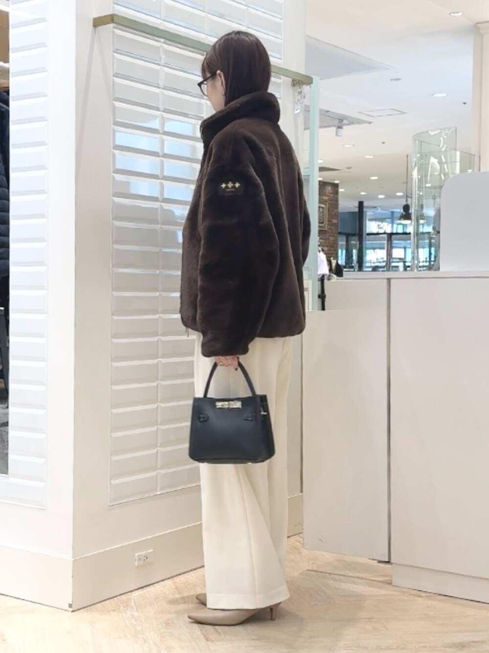 ホワイト系のその他パンツ、ブラック系のショルダーバッグ、ブラウン系のタンクトップを着用したレディースの秋コーディネートの3枚目の写真