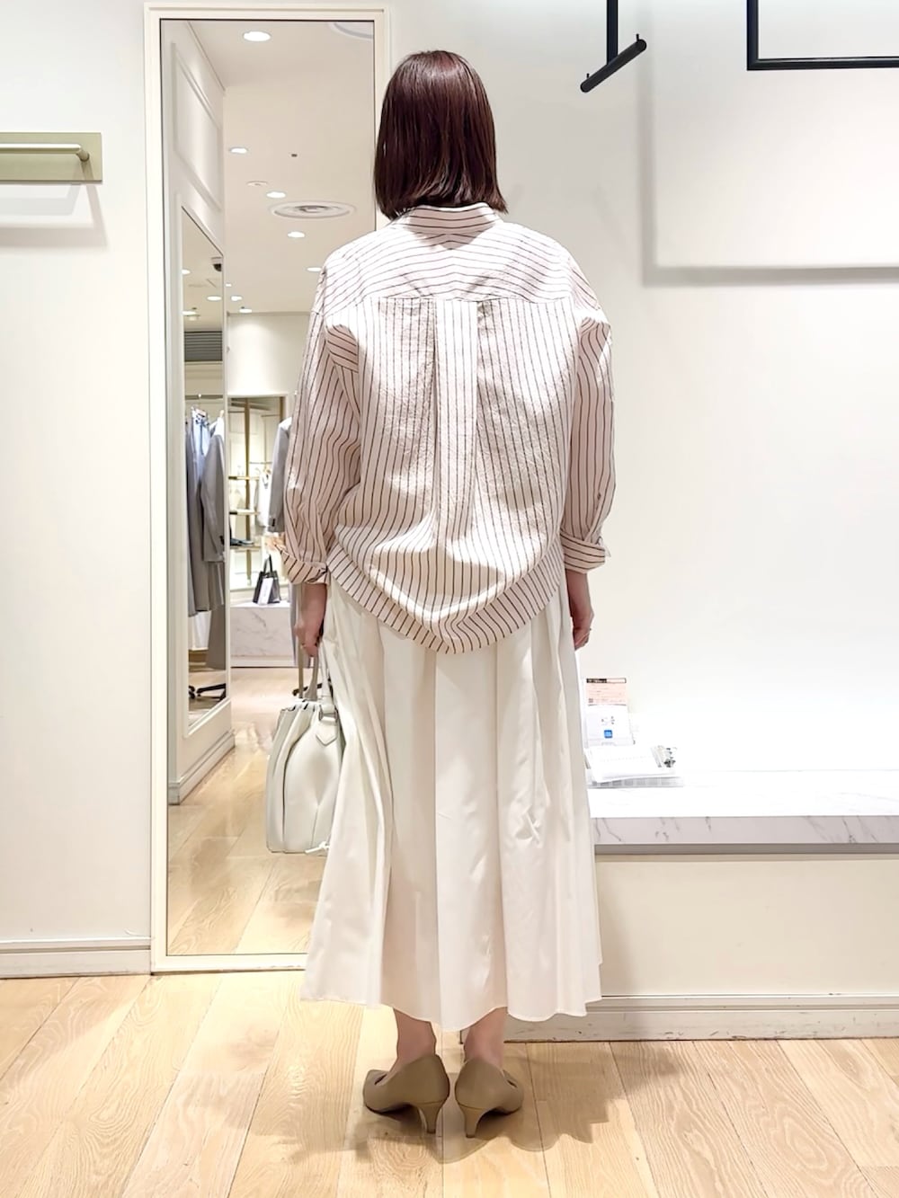 ホワイト系のスカート、ピンク系のシャツ/ブラウス、グレー系のネックレスを着用したレディースの春コーディネートの3枚目の写真