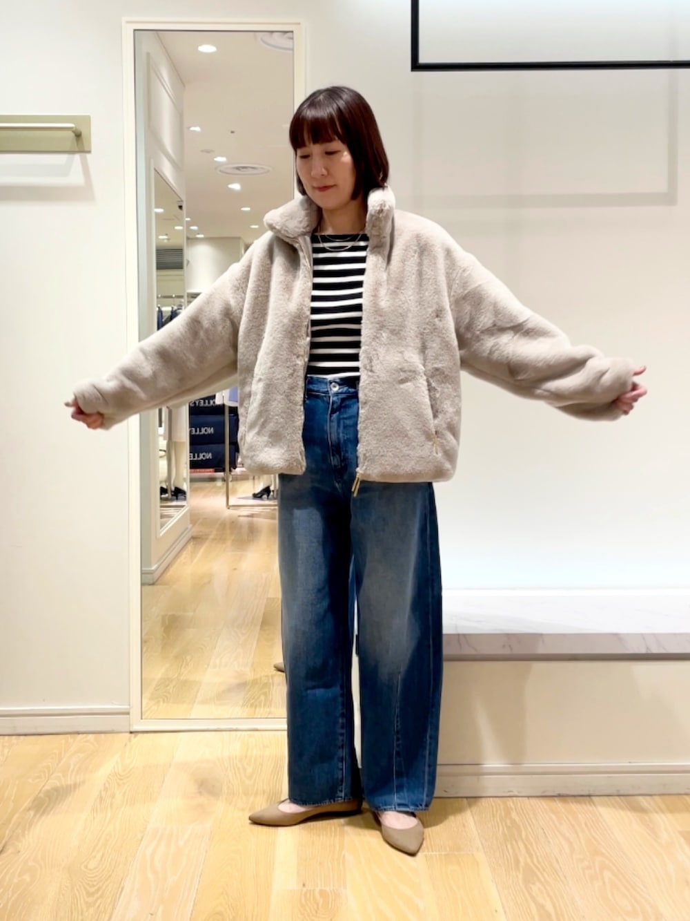 ブルー系のデニムパンツ、グレー系のブルゾン、ブラック系のニット/セーターを着用したレディースの秋コーディネートの6枚目の写真