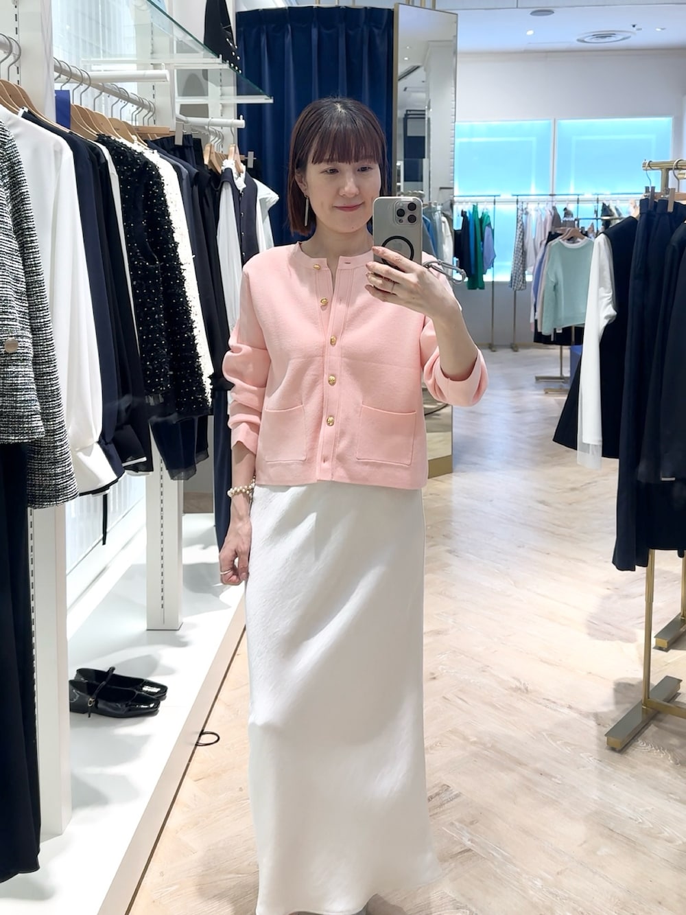 ホワイト系のスカート、ピンク系のカーディガン/ボレロ、ホワイト系のネックレスを着用したレディースの春コーディネートの2枚目の写真