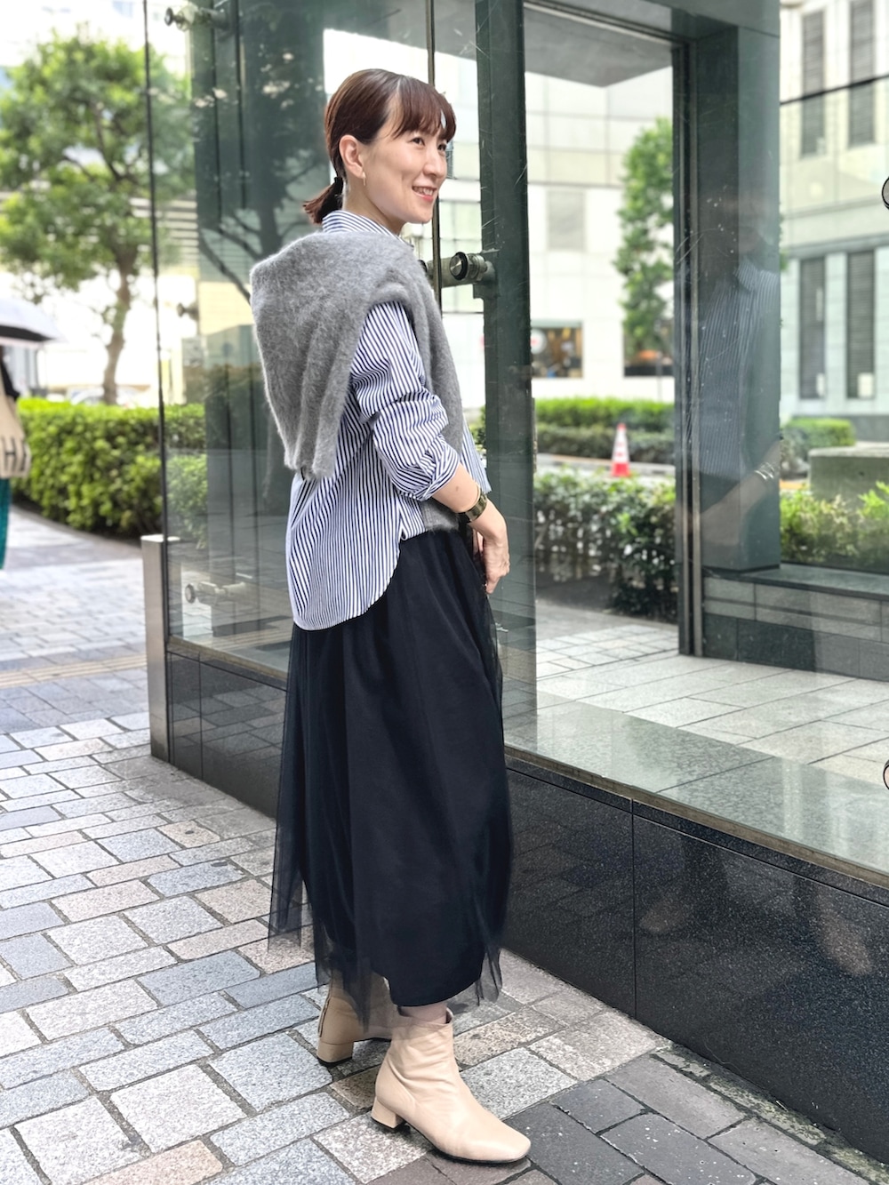 ブラック系のワンピース、ブラック系のショルダーバッグ、ブルー系のシャツ/ブラウスを着用したレディースの秋コーディネートの3枚目の写真